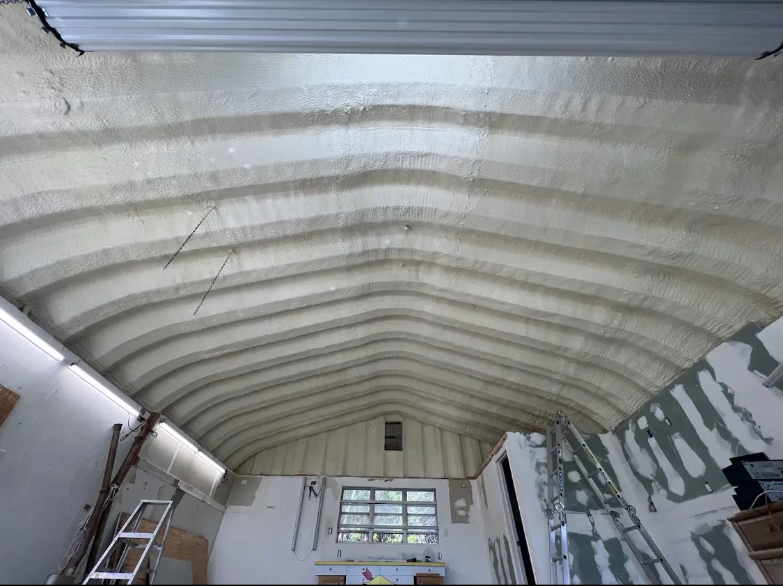 Spray polyurethane foam applied to the underside of a metal roof deck in Sienna